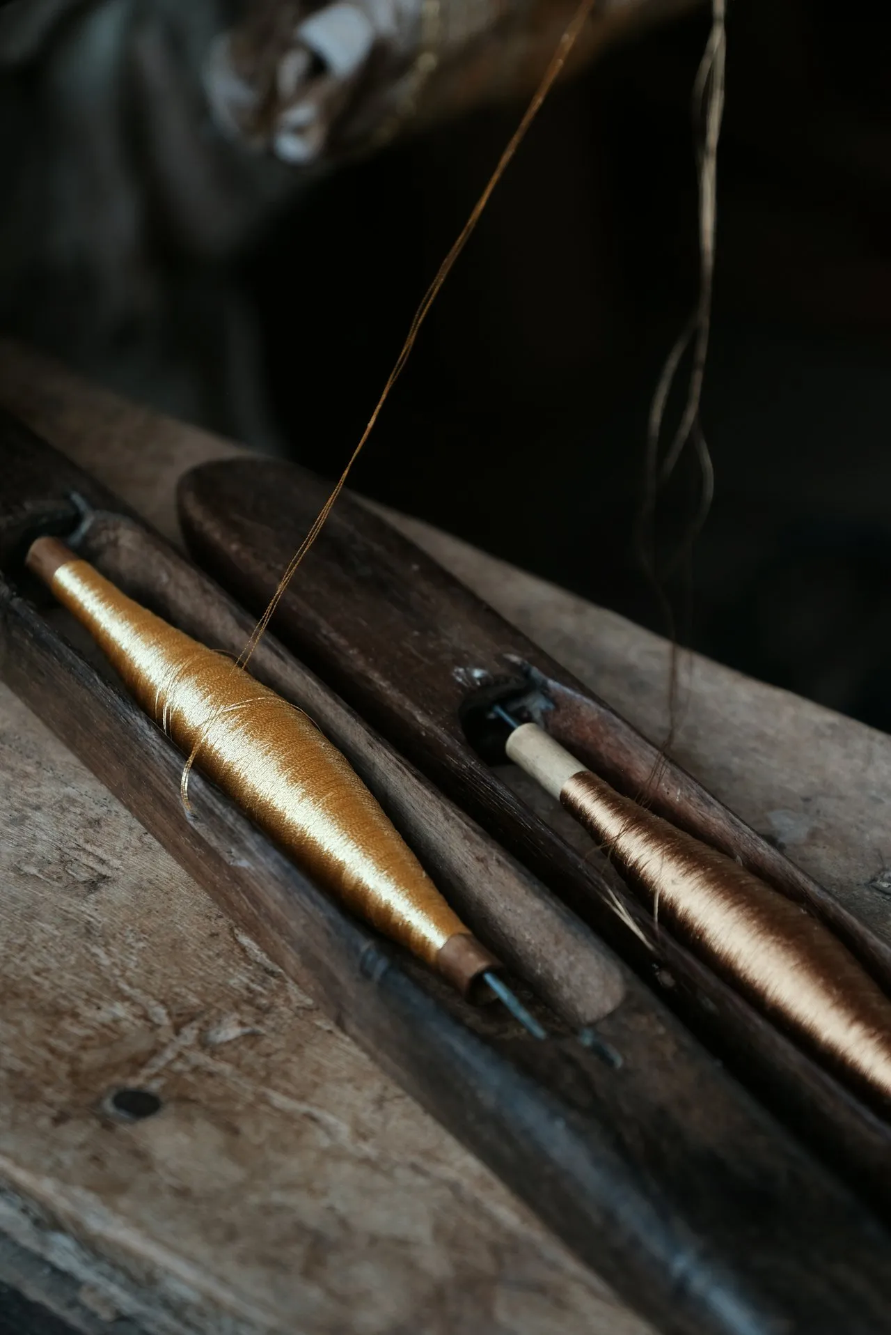 A single fish hook in extreme close-up, the barb catching the light — bait with a point you don't see until it's set.